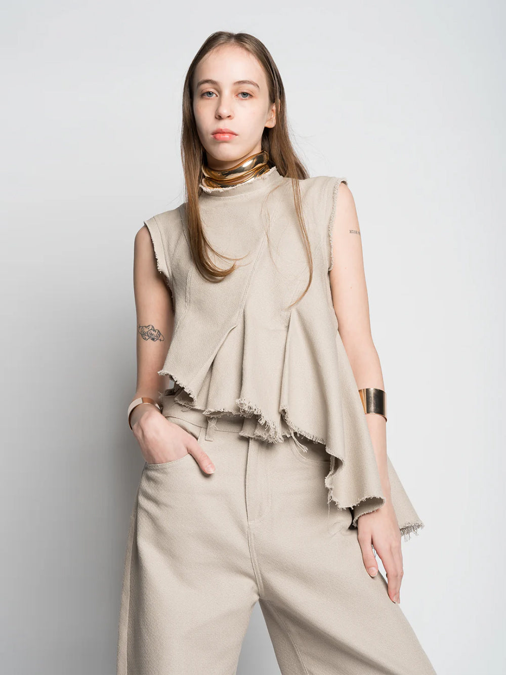 Woven Cotton Sleeveless Top With Stitched Pleats And Assymetric Flounce Hem Beige